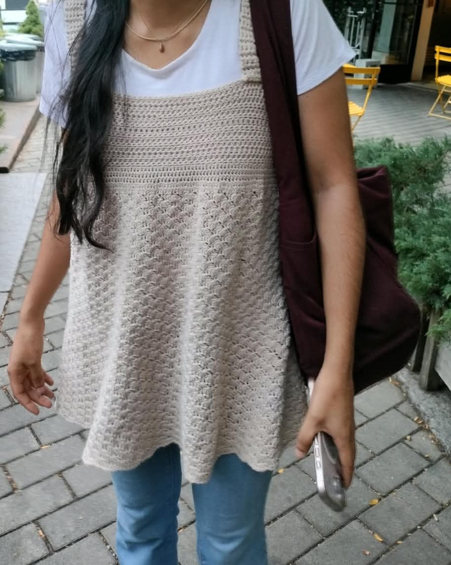 A cream-colored crocheted top with a textured flared body